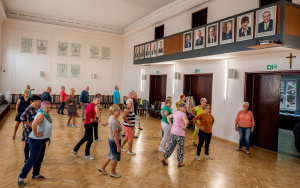 Uczestnicy słuchając instruktora wykonują ruchy taneczne