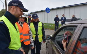 Policjanci z KPP rozmawiają z kierowcą, w tle Starosta i Zastępca Komendanta Powiatowego Policji w Będzinie